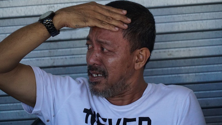 A Marawi police officer holds his forehead as he recounts his escape from Islamic State.