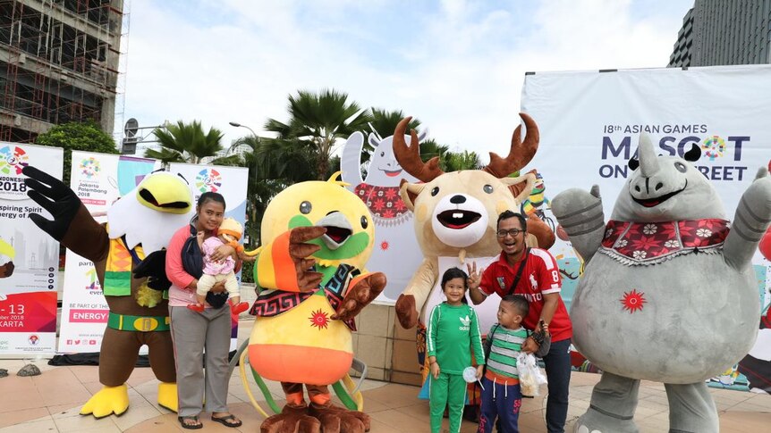 Families pose with mascot's of the Asian Games