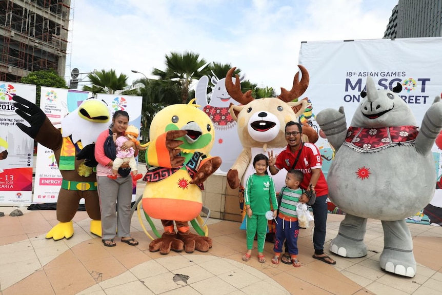 Families pose with mascot's of the Asian Games