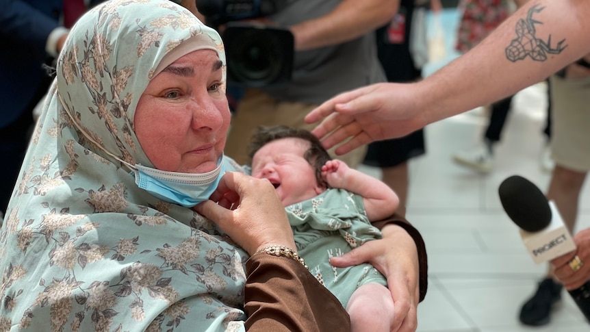 An old woman with a crying baby.