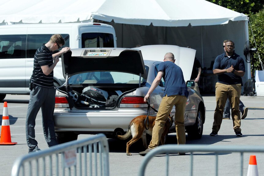 Secret service personnel with a sniffer dog check a vehicle coming into Mar-a-Lago resort.