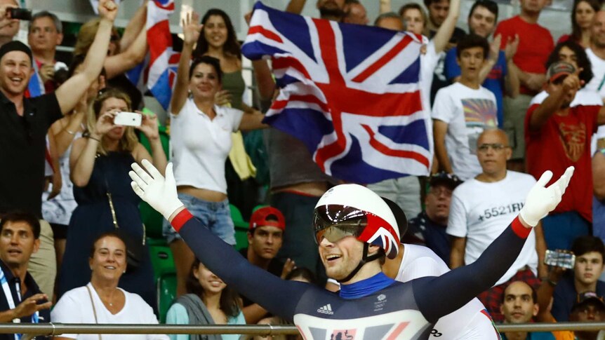 Jason Kenny holds his hands in the air, smiling