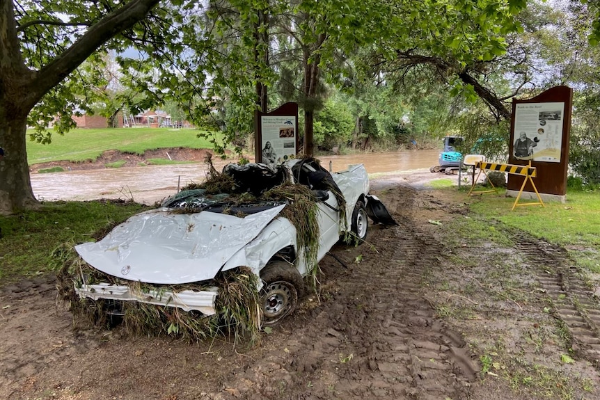flattened car covered in flood debris
