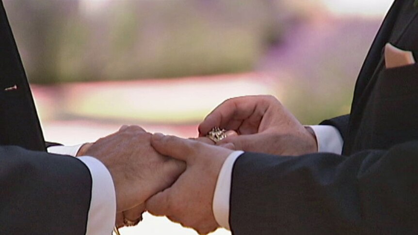 Men exchange wedding rings