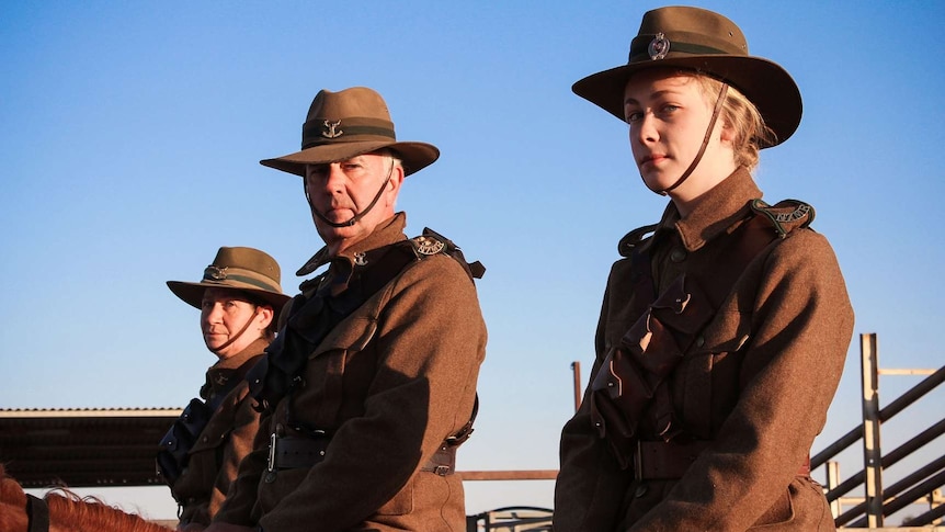 Three people dressed in New Zealand WWI uniforms on horseback