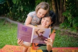 Anna Ralph and Vita read 'The Magic Cure' together in the backyard.