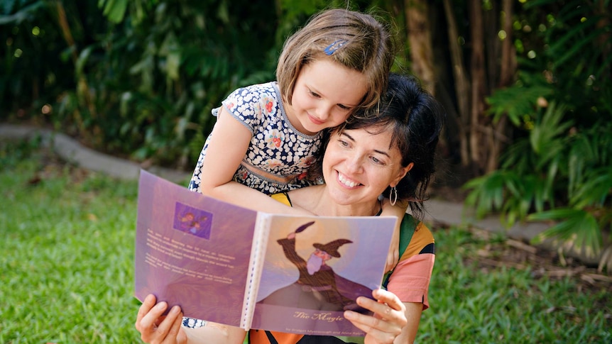 Anna Ralph and Vita read 'The Magic Cure' together in the backyard.