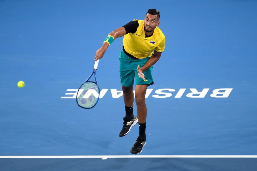 An Australian tennis player is captured mid-serve, with his racquet in the follow-through.