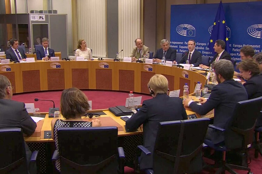 Facebook's CEO Mark Zuckerberg sits at a circular table with EU Parliament leaders.