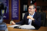 Northern Territory Chief Minister Michael Gunner sits at a desk.