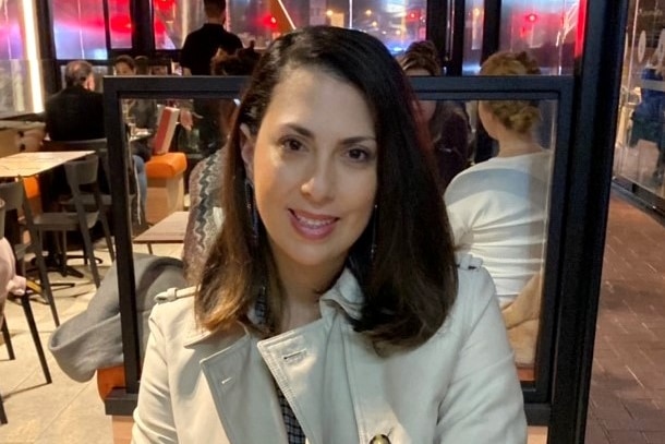 Deema Audeh sitting in a restaurant wearing a brown coat