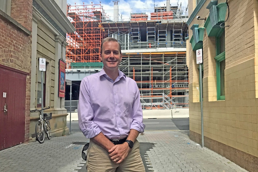 Liberal MP Michael Ferguson standing in front of Royal Hobart Hospital redevelopment.