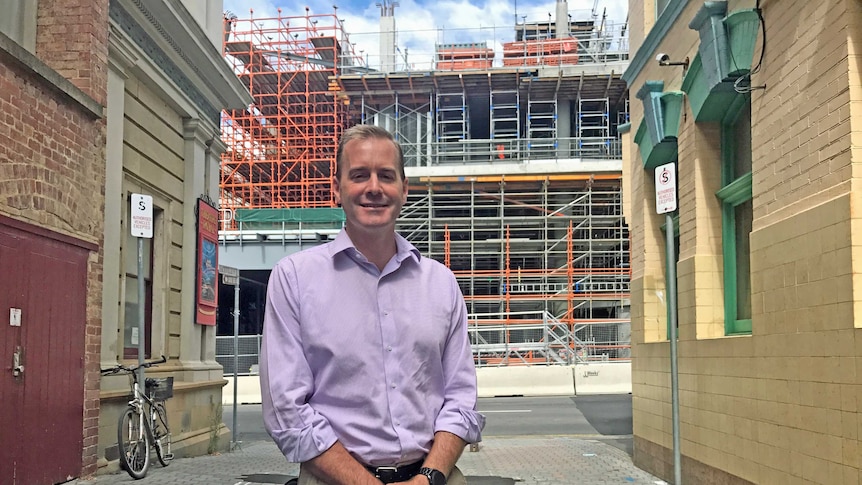 Liberal MP Michael Ferguson standing in front of Royal Hobart Hospital redevelopment.