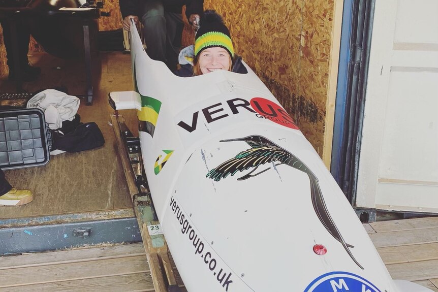 Woman sitting in bobsled smiling