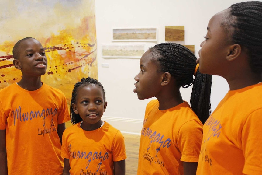 Four African children singing.
