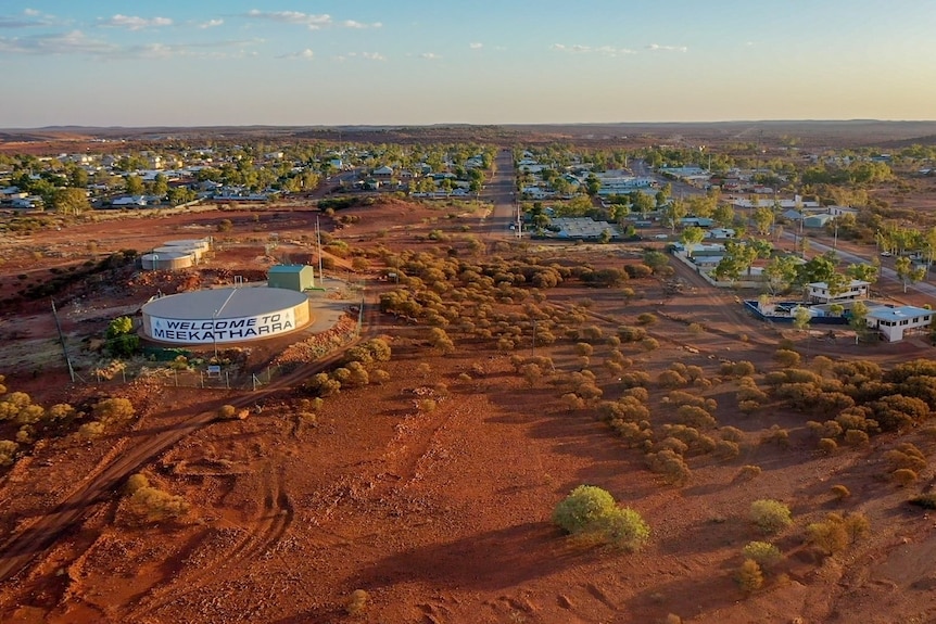 Drone picture from the air of the town of Meekatharra. A water tower with "Welcome to Meekatharra" stands in the foreground 