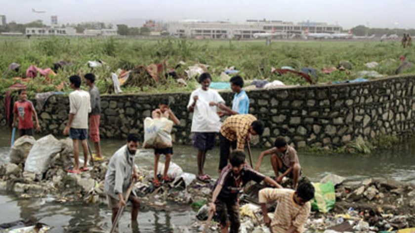 Indian slum dwellers hunt for valuables washed away by the recent floods in Mumbai.