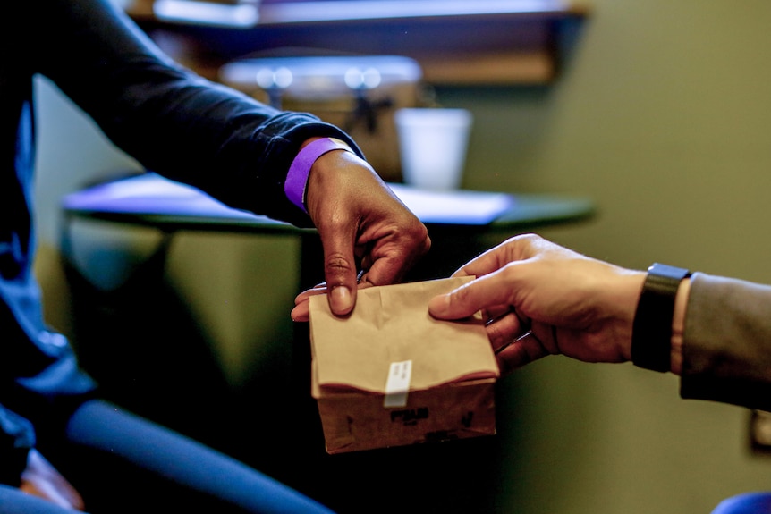 A doctor hands a bag to her patient.