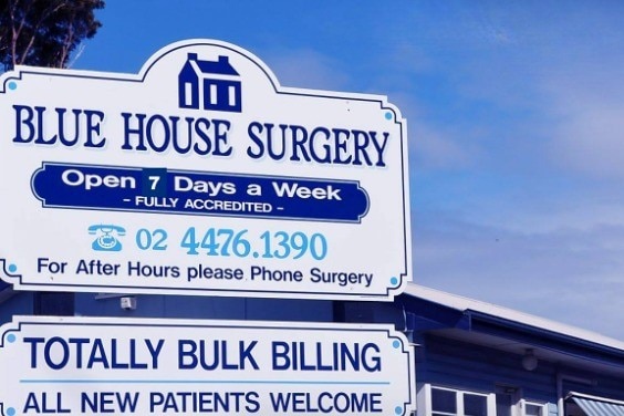 A Blue House Surgery sign with opening hours and contact details listed.