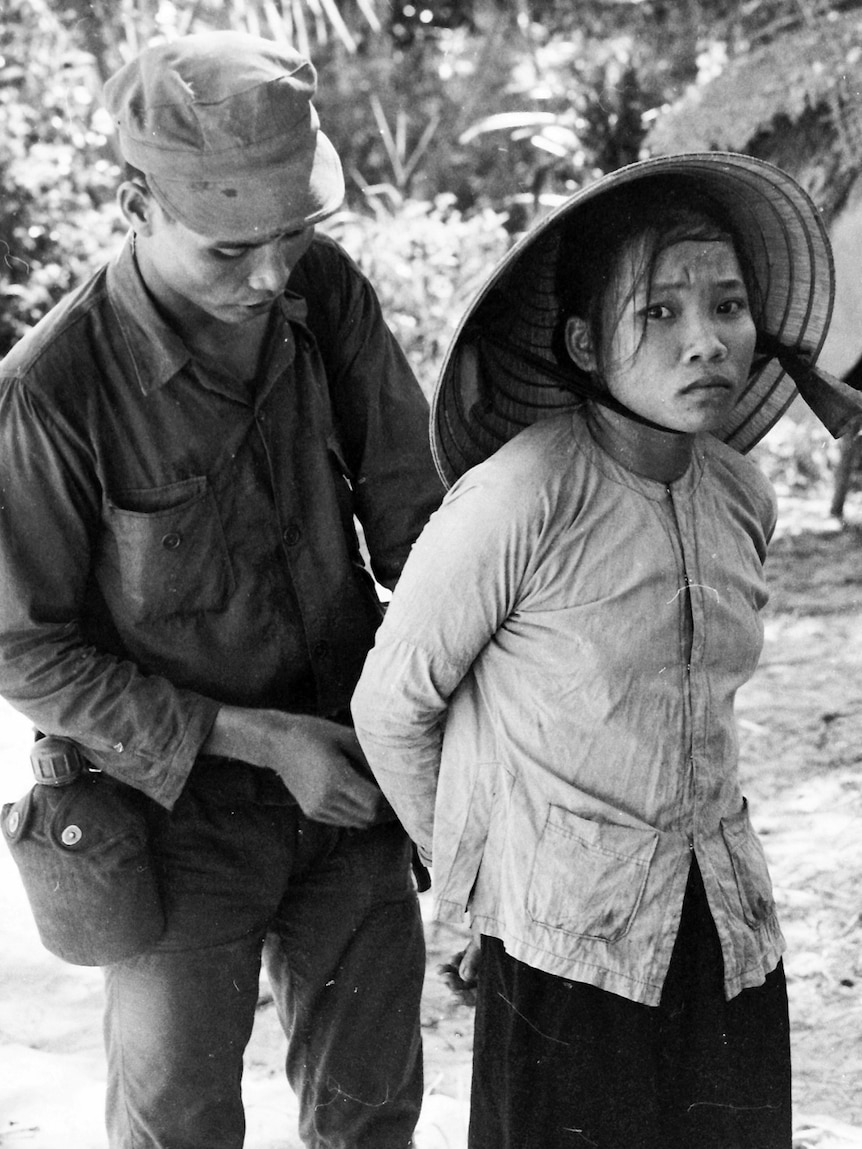 A South Vietnamese Army soldier detaining a woman