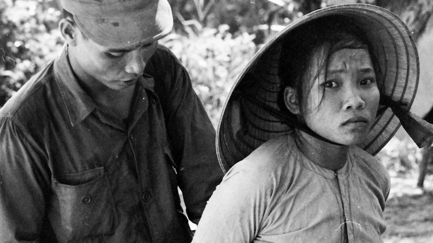A South Vietnamese Army soldier detaining a woman