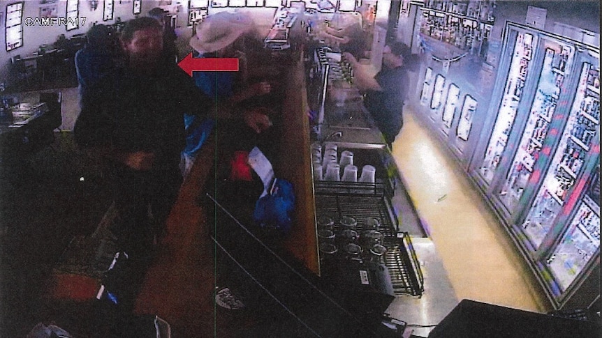 A still frame from CCTV footage showing men ordering drinks at the bar in a pub.