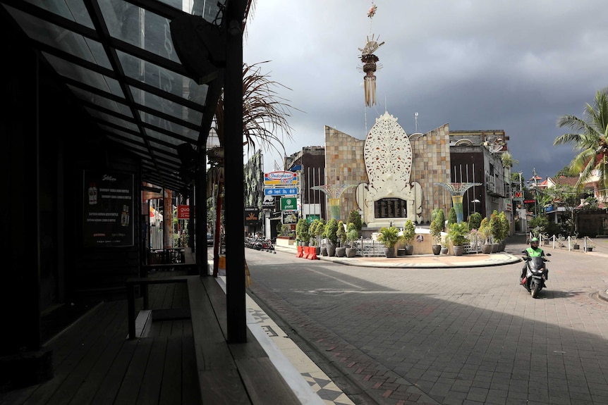 A motorist passes Ground Zero Memorial in Legian, where the streets are empty.