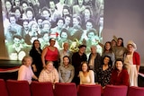 A large group of women in front of a projected image. 