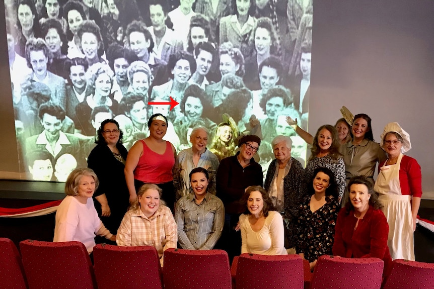 A large group of women in front of a projected image. 