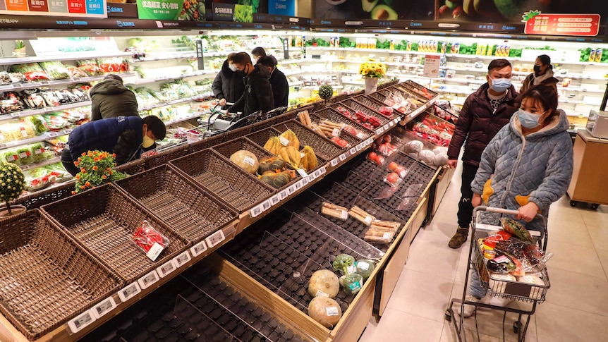 Women and men wearing masks in a supermarket where has limited stock of food.