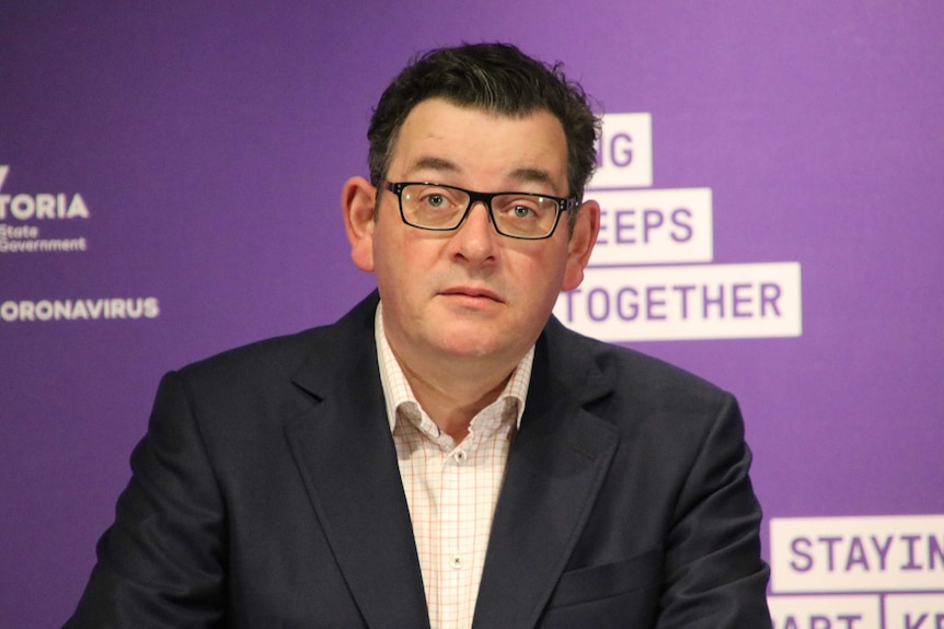 Victorian Premier Daniel Andrews at a press conference staring straight ahead.