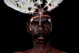A portrait of an Indigenous man who is about to perform in a dancing troupe.