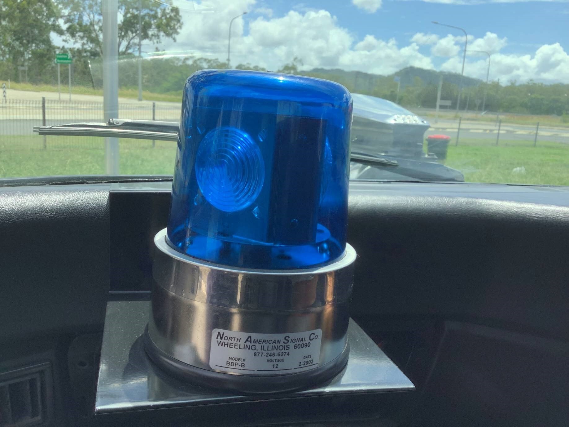 A blue police light on a car dashboard