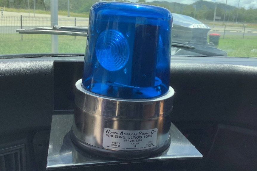 A blue police light on a car dashboard