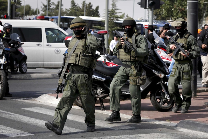 Israeli paramilitary police officers walk near the scene of a stabbing in Jerusalem.