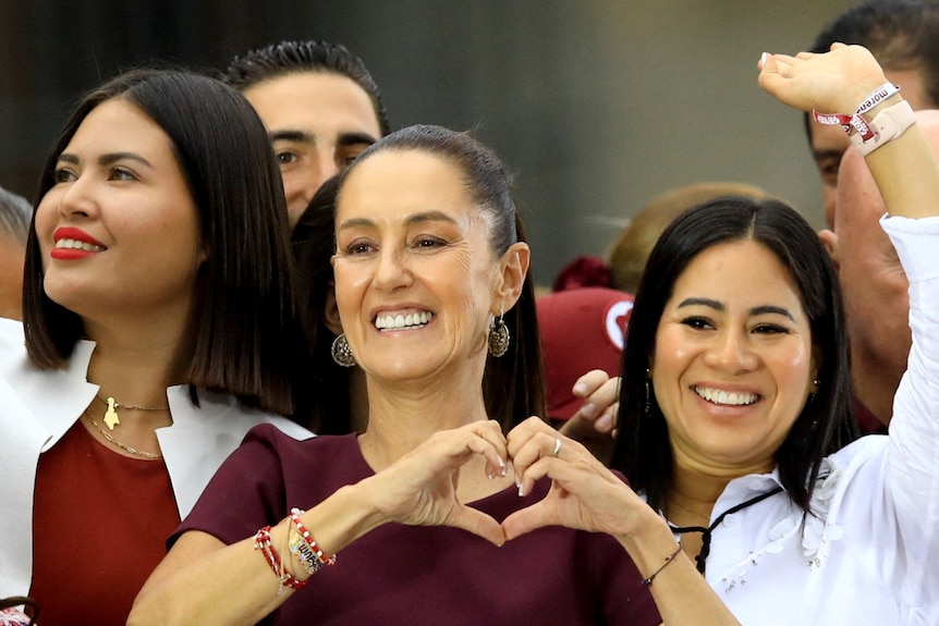 A woman holds her hands together to make a love-heart shape 