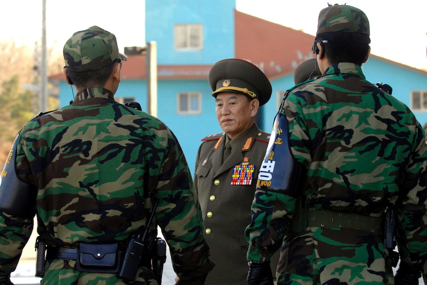 North Korea's chief delegate Kim Yong-Chol walks by South Korean soldiers.