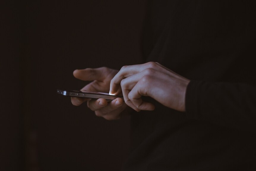 A close-up of a person's hands using a mobile phone