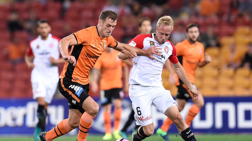 Luke De Vere of the Brisbane Roar (left) and Mitch Nichols of the Western Sydney Wanderers compete for the ball.