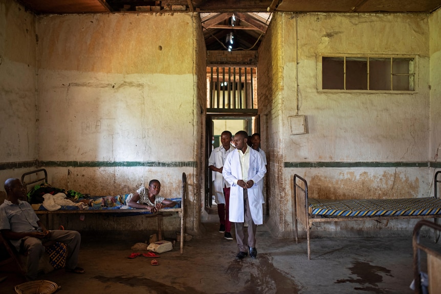 A doctor walks into a hospital room with two beds in the Democratic Republic of Congo 