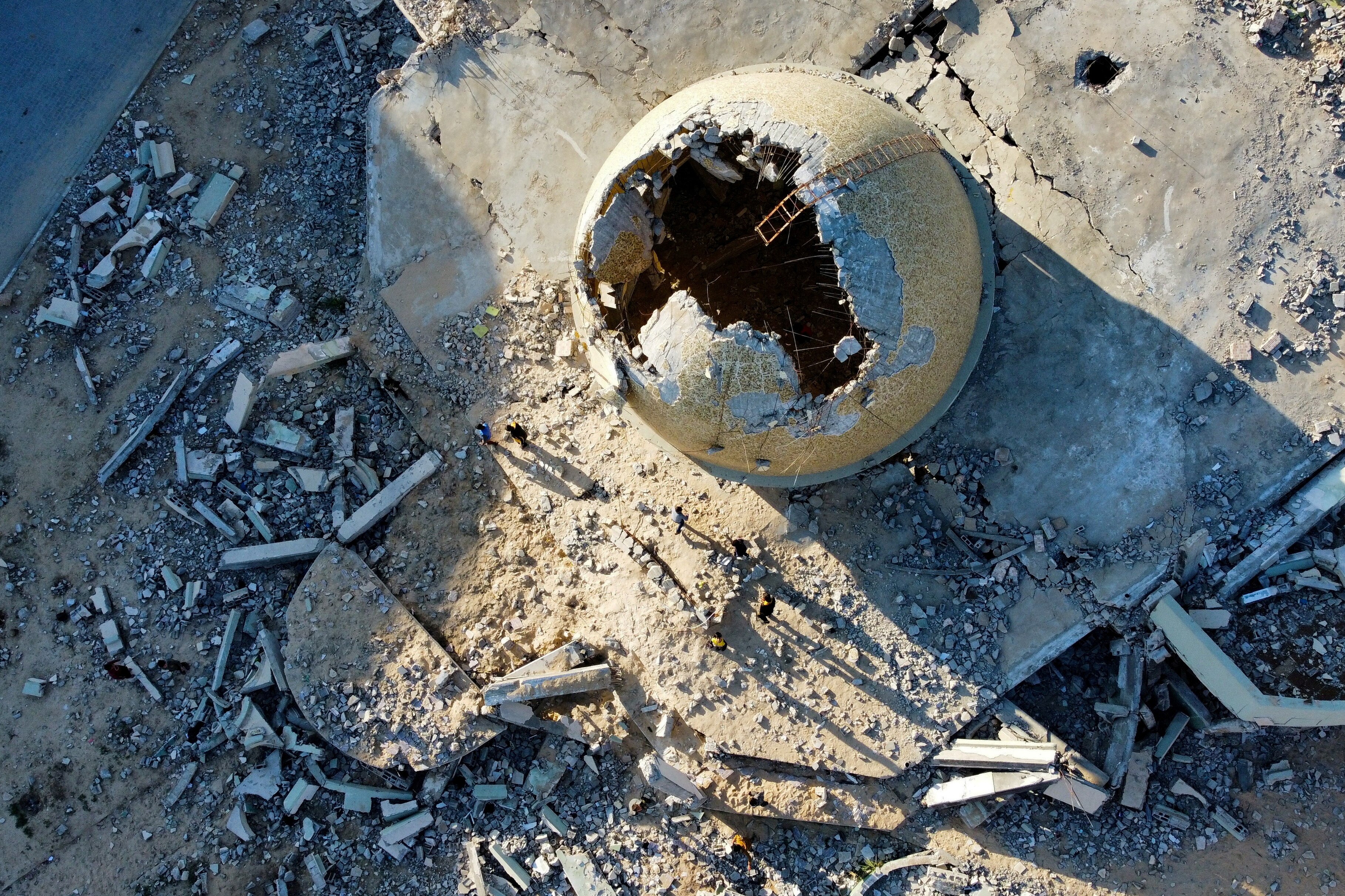 A mosque dome partially destroyed among rubble
