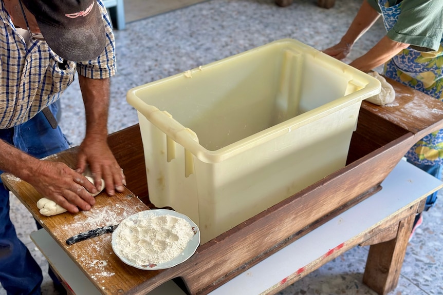 Action shot of a man's hands kneading bread dough