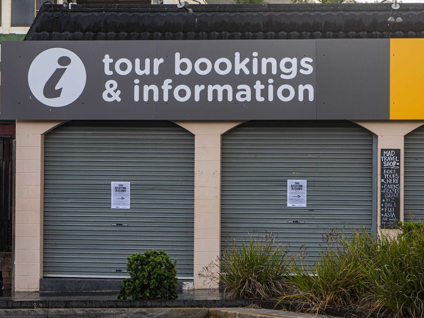 A line of roller doors shuttered at a tourism information centre.