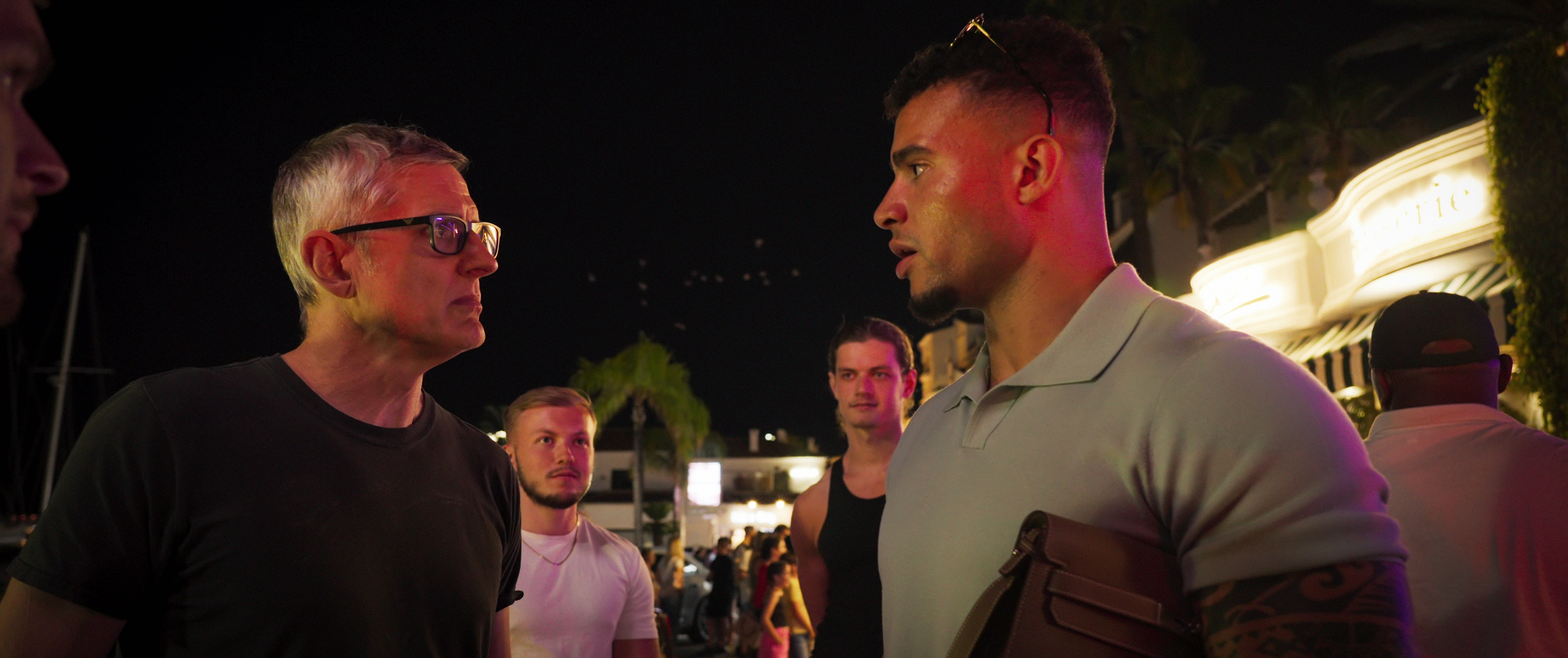 Dos hombres se miran fijamente afuera.