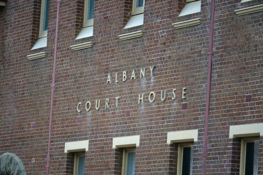 A sign on a brick wall saying "Albany Court House"