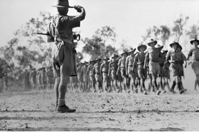 Monochrome of army general saluting marching soldiers.