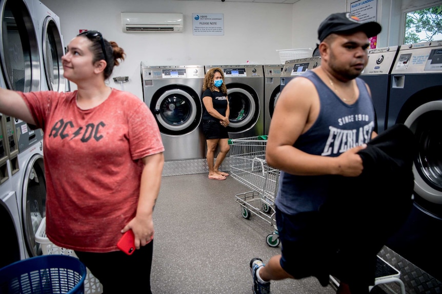 A laundromat with three people inside