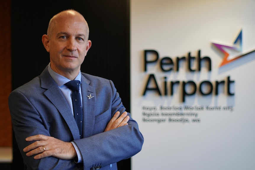 Le directeur général de l'aéroport de Perth, Kevin Brown, debout à côté d'un panneau de l'aéroport.