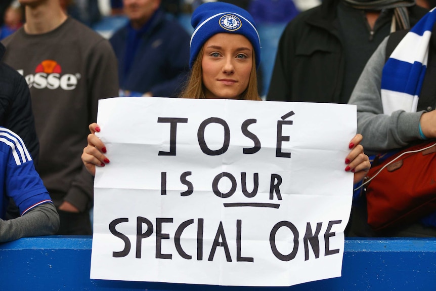 A Chelsea fan holds a sign in support of Jose Mourinho