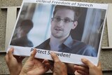 Supports hold up a picture of Edward Snowden